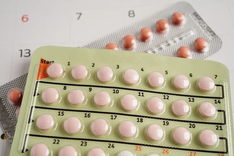 Close-up of 21-day and 28-day combination birth control pill packs for menstrual cycle regulation.