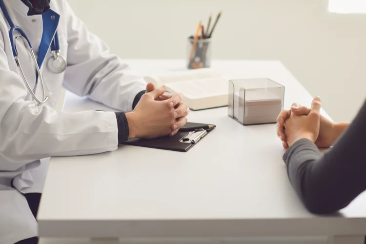 Doctor and patient discussing SPOT-MAS cancer blood test during a medical consultation in clinic.