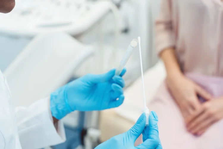 Doctor preparing vaginal swab test to diagnose candidiasis infection in clinical examination.