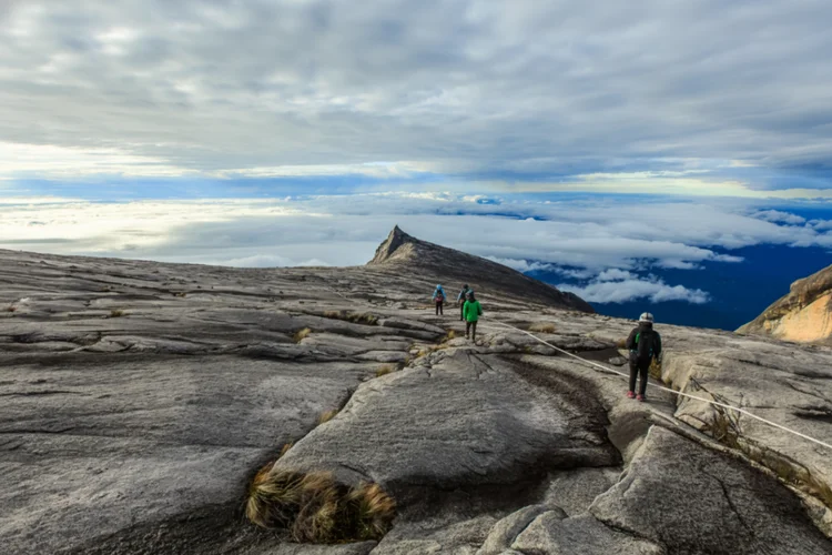 Group of hikers ascending mountain slowly illustrating gradual ascent to prevent altitude sickness.
