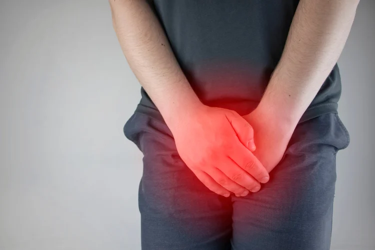 Man holding lower abdomen in pain indicating ureaplasma infection symptoms such as burning urination.