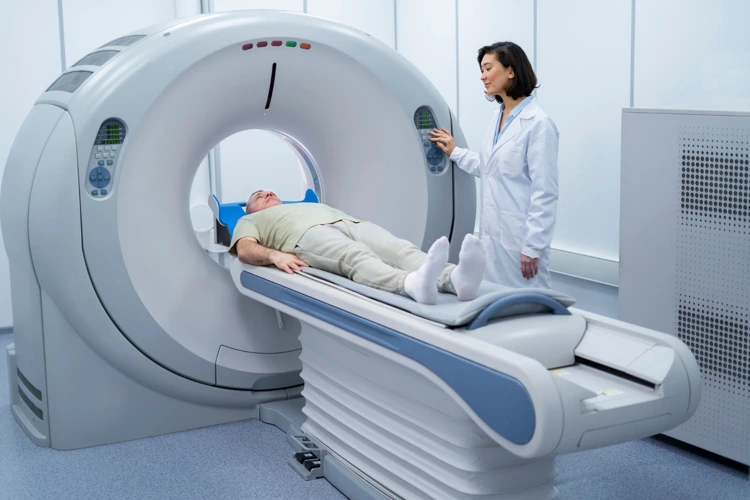 Patient undergoing MRI scan at clinic with radiologist operating the MRI scanner.