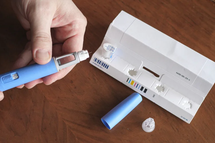Patient holding liraglutide injection pen for daily use in type 2 diabetes and weight management.