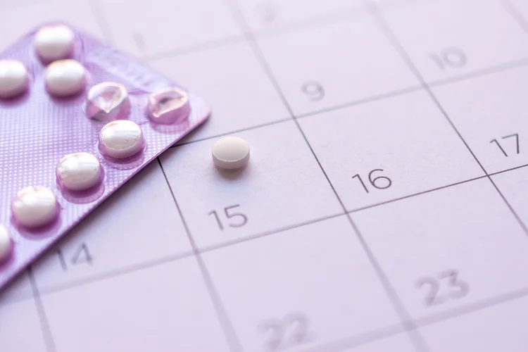 Period delay pill on calendar representing how norethisterone delays periods for travel or events.